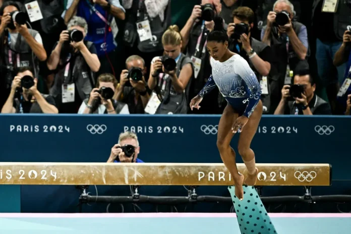 Simone Biles falls on the balance beam during the Paris 2024 Olympics, missing out on a gold medal.